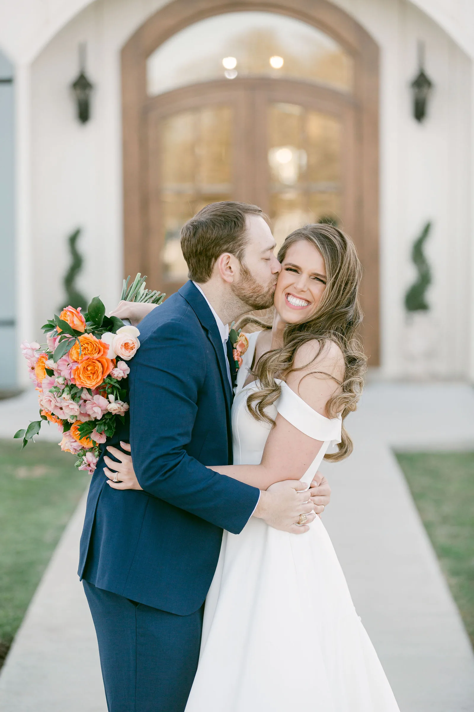 Bride and groom portrait in front of The French Farmhouse main building.