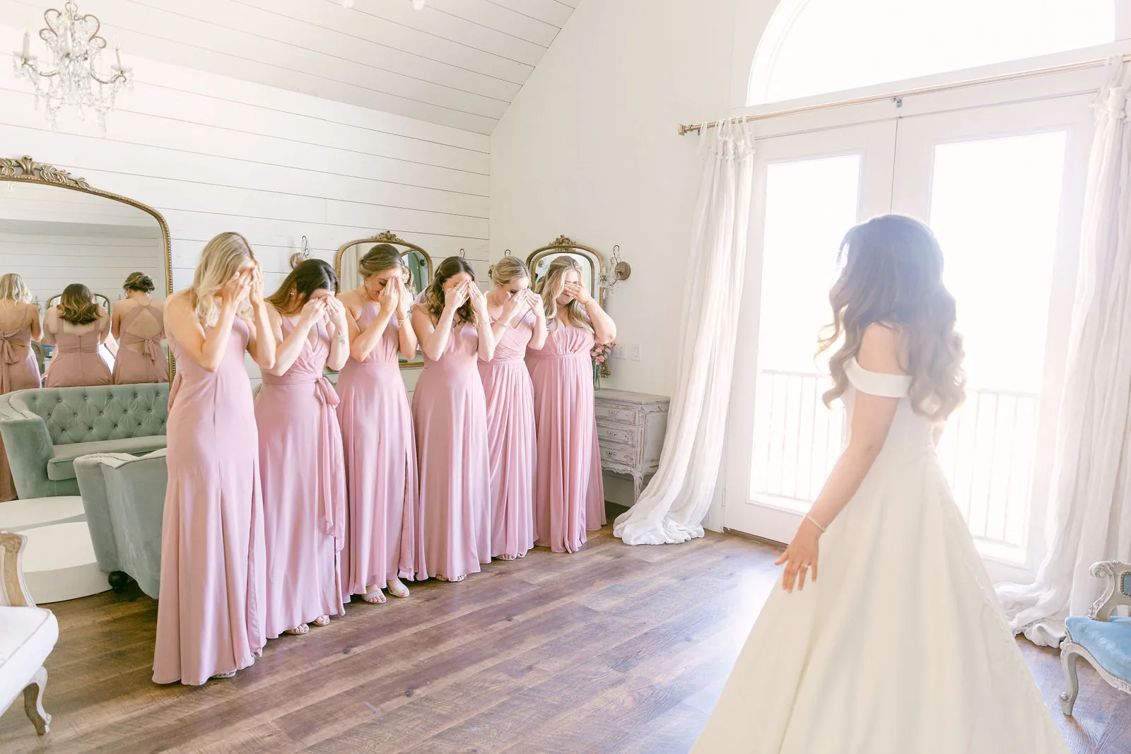 Bridesmaids reacting during getting ready in the bridal suite.