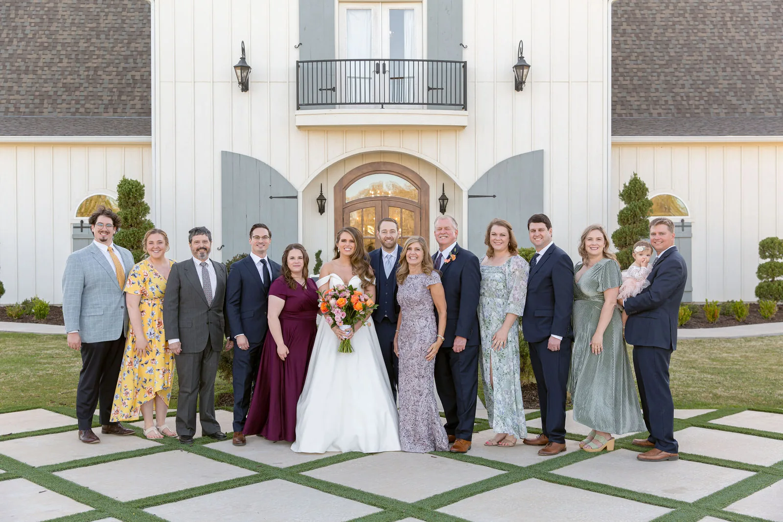 Large wedding party group photograph in front of The French Farmhouse main building.