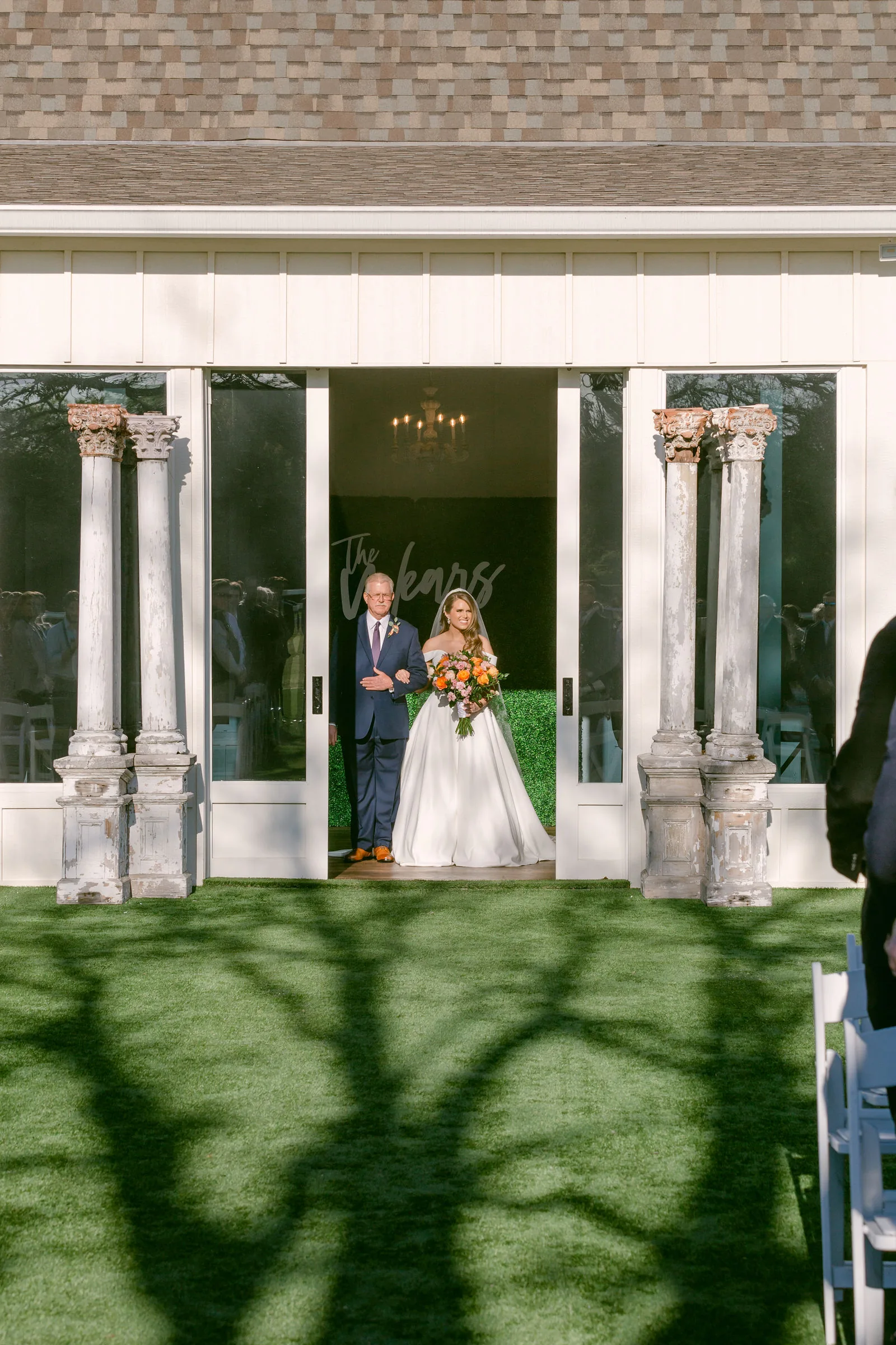 Pronounced bare-branch shadows falling across the outdoor ceremony aisle.