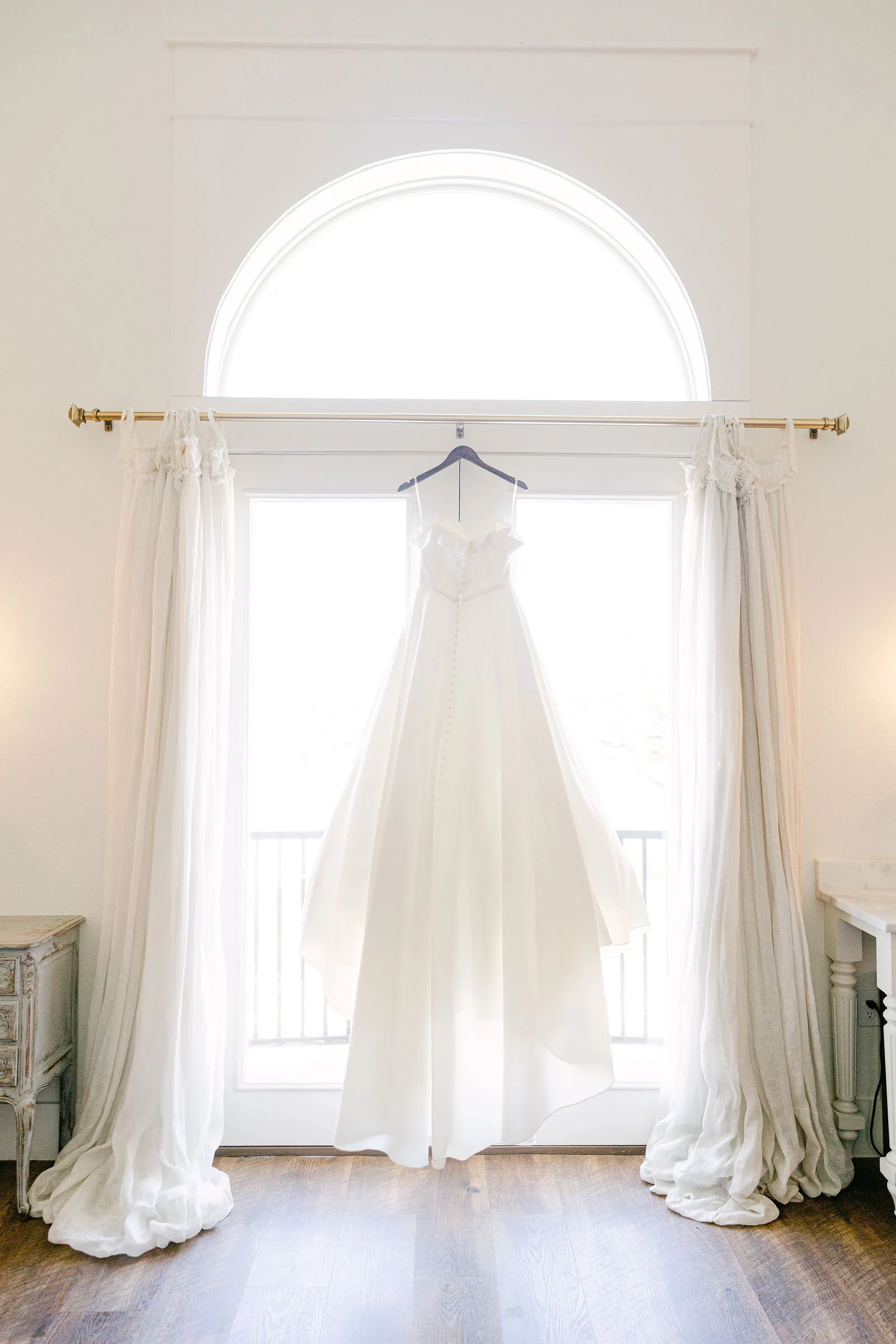 Wedding dress hanging in the bridal suite window at The French Farmhouse.